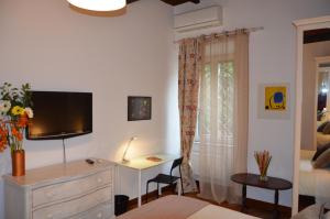 ローマにあるBenedetta Trastevereのベッドルーム1室(壁にテレビ付きのドレッサー付)