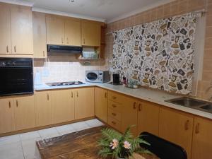 a kitchen with wooden cabinets and a stone wall at Lindas Haven in Swakopmund
