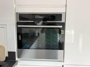 a microwave oven in a kitchen with a person inside at Cozy Suite La Défense in Nanterre +14 photos