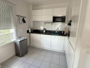 a white kitchen with a sink and a microwave at Cozy Suite La Défense in Nanterre