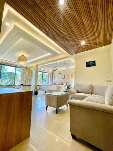 a living room with two couches and a living room with a table at Casa Amarilla Hotel in Dona Paula +4 photos