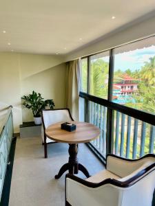 a table and chairs in a room with a balcony at Casa Amarilla Hotel in Dona Paula