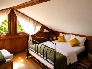 ein Schlafzimmer mit einem Bett mit weißen Laken und gelben Kissen in der Unterkunft La Cascade - Casa de vacanta in Fîntînele