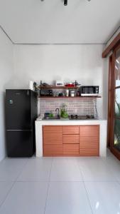 a kitchen with a black refrigerator in a room at Arrum Villa in Ungasan