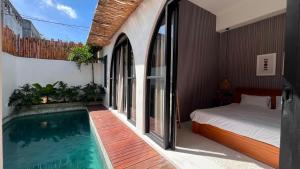 a bedroom with a bed and a swimming pool at Arrum Villa in Ungasan