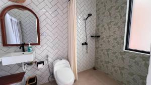 a bathroom with a toilet and a sink and a mirror at Arrum Villa in Ungasan