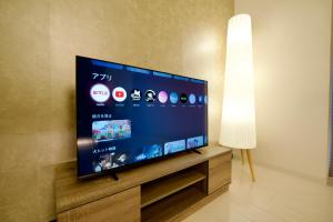 a flat screen tv sitting on a stand next to a lamp at Grand Success Kotoni ll in Sapporo +71 photos