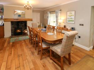 a dining room with a table and chairs and a fireplace at North Studdock Cottage in Pembroke