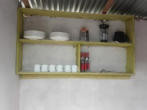 a wooden shelf with plates and cups on it at Bububu creek house in Mombasa