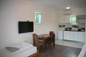 a kitchen and a dining room with a table and chairs at B&I apartmani in Glavatske Kućice