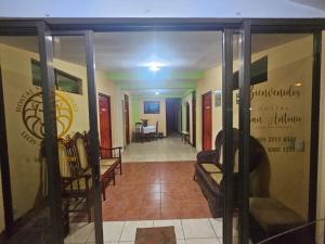 a hallway with a door open to a room with chairs at Hostal San Antonio in León