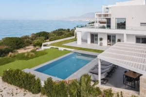 an aerial view of a house with a swimming pool and the ocean at Nouvelle Villa in Ierapetra