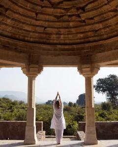 a woman doing a yoga pose under a pavilion at Surya Bagh - A Luxury Hideaway - 5 minutes to Ajabgarh, 10 minutes to Bhangarh & 20 minutes to Tehla, Sariska in Ajabgarh