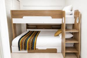 two bunk beds in a small room with white walls at Rubens Hakata -ルーベンス博多- in Fukuoka