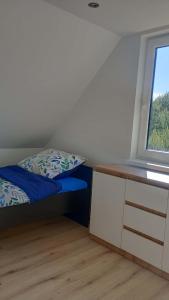 a small bedroom with a bed and a window at Domek letniskowy Płaska in Płaska