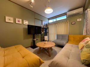 a living room with a couch and a table at 花の宿 別府 in Beppu