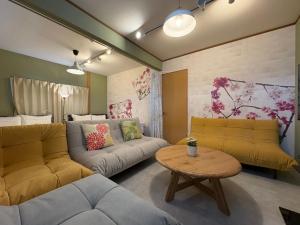a living room with a couch and a table at 花の宿 別府 in Beppu