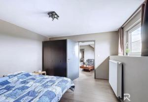 a bedroom with a bed and a large window at Zur alten schule in Amblève