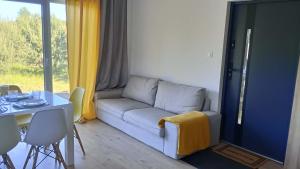 a living room with a couch and a table at Domek letniskowy Płaska in Płaska +18 photos
