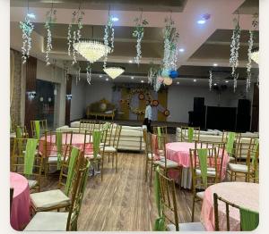a room with tables and chairs with pink and greenitures at YU Turn Celebrations in Greater Noida +4 photos