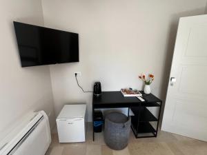 a room with a black desk with a television on the wall at Affittacamere gold 5 in Barletta