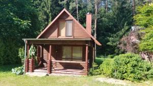 a small cabin in a field with trees at A&S Vidugiris in Jurbarkas