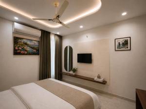a bedroom with a bed and a flat screen tv at Hotel RajKailash in Jaipur +35 photos
