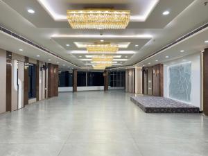 a lobby with a large hall with a bed and chandeliers at Hotel RajKailash in Jaipur