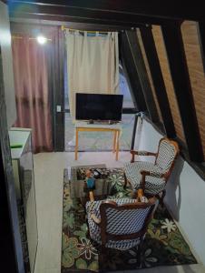 a living room with two chairs and a flat screen tv at Casa paula in San Agustín