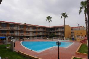 a hotel with a swimming pool and palm trees at Quality Inn Piedras Negras in Piedras Negras +81 photos