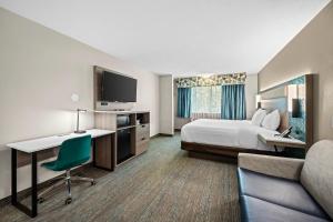 a hotel room with a bed and a desk and a tv at Econo Lodge Inn & Suites Santa Fe South in Santa Fe