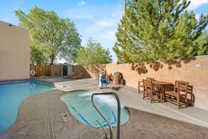 a backyard with a swimming pool and a table and chairs at Econo Lodge Inn & Suites Santa Fe South in Santa Fe