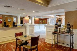 a lobby with a table and chairs and a bar at Quality Suites San Antonio Northeast in San Antonio