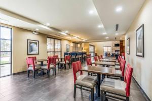 a restaurant with red chairs and tables and windows at Comfort Suites Channelview - Houston East in Channelview
