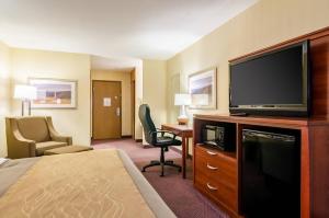 a hotel room with a bed and a flat screen tv at Quality Inn & Suites Colby in Colby