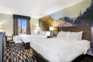 a hotel room with two beds and a painting on the wall at Clarion Pointe Richmond North near University in Richmond
