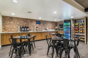 a restaurant with tables and chairs and a counter at Clarion Pointe Richmond North near University in Richmond