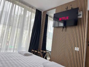 a bedroom with a bed and a television on the wall at Diamond Resort Busteni in Buşteni