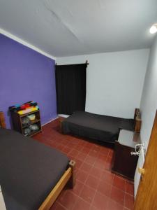 a bedroom with two beds and a purple wall at La casita de José in Villa Unión