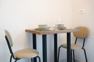 a table with two chairs and a table with plates and bowls at Luxury Studio Chiajna in Roşu +6 photos