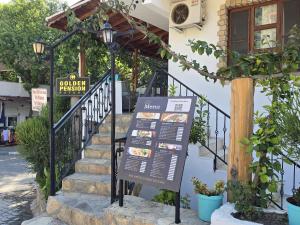 a sign in front of a house with a porch at Golden Pension in Patara