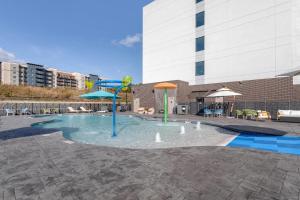 a pool with a water slide in a building at Cambria Hotel Pigeon Forge in Pigeon Forge