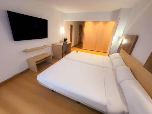 a room with a white couch and a flat screen tv at Hotel Faranda Alisas Santander, Ascend Hotel Collection in Santander