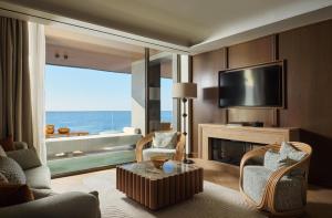 a living room with a fireplace and a television at Hilton Chania Old Town Resort & Spa in Chania