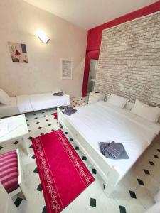 a bedroom with two beds and a brick wall at Hotel Trakia in Plovdiv