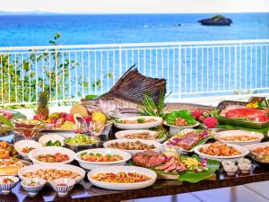 a buffet of food on a table next to the ocean at Hotel Resonex Nago in Nago