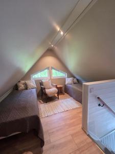 a attic room with a bed and a chair at Gammeleken in Stidsvig