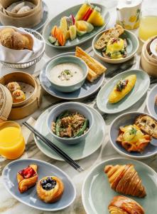 a table topped with plates of food and desserts at Andaz One Bangkok, by Hyatt in Bangkok