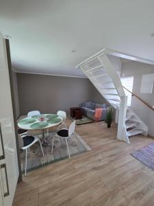 a living room with a table and chairs and a staircase at Gammeleken in Stidsvig