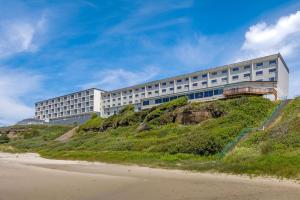 a building on top of a hill next to a beach at Newport Oceanfront Inn in Newport